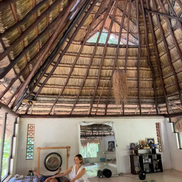 Open-air casita with hardwood floor, branch partition and sofa opening to the jungle